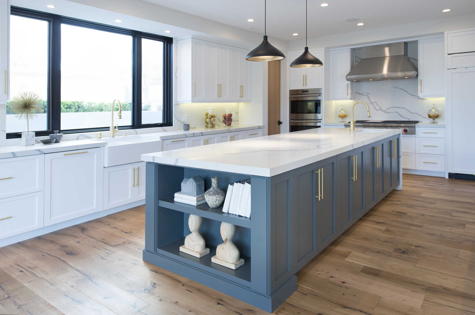 Chef's kitchen with marble waterfall island and brass fixtures