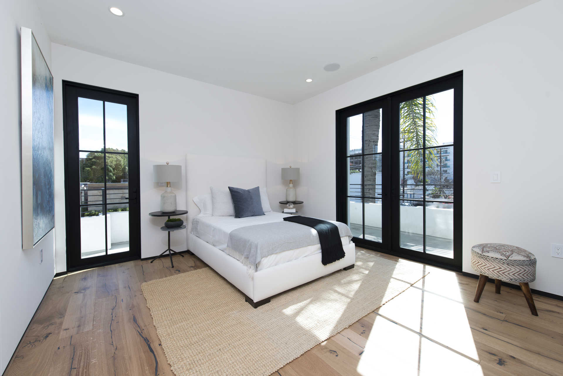 Secondary bedroom with steel-frame doors to private balcony
